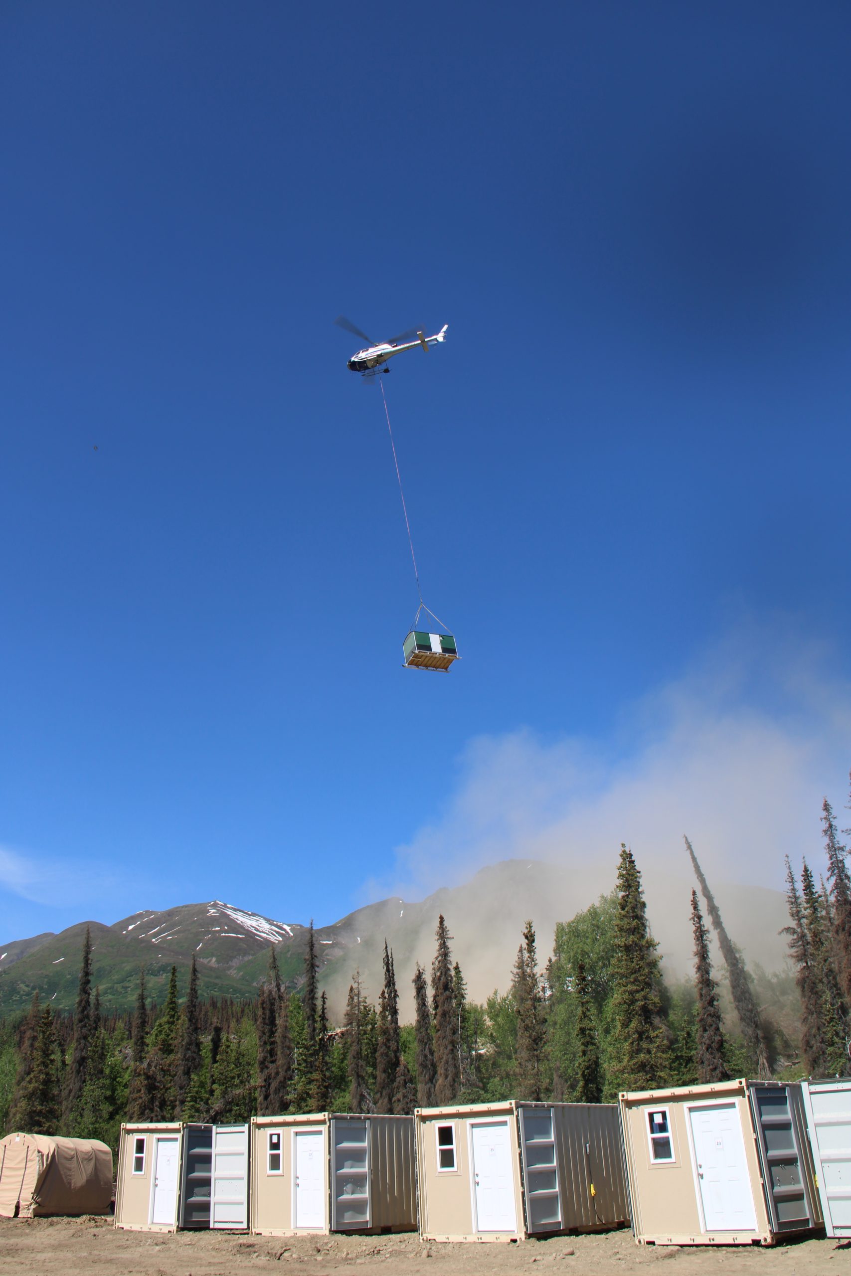 Photo of helicopter flying a safety hut away from the camp site to RPM